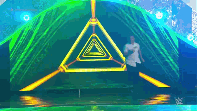 a man is dancing on a stage in front of a pyramid