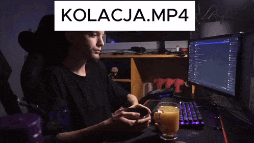 a man sits in front of a computer with kolacja.mp4 written on the top