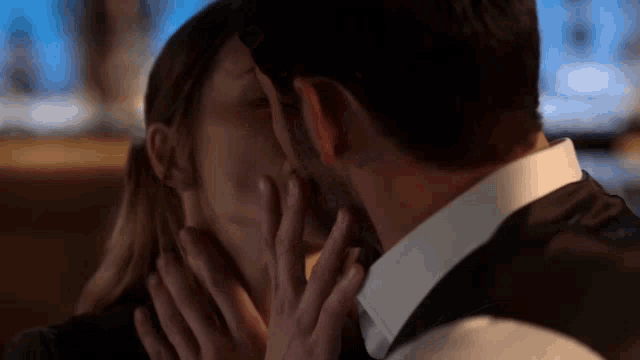 a man and a woman are kissing in a dark room
