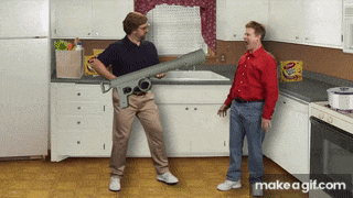 two men standing in a kitchen holding a giant rocket launcher made by makeagif.com