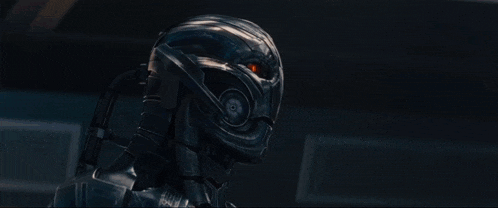 a robot is holding a gun in a room with a light shining on it .