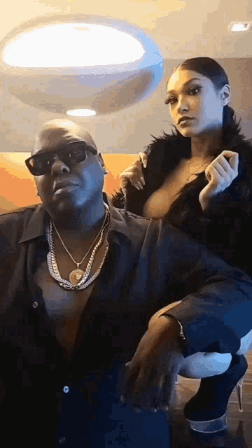 a man and a woman are posing for a picture and the woman is wearing a fur coat