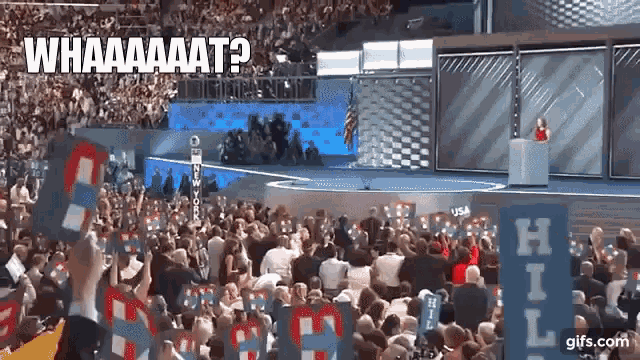 a crowd of people watching a speech with a sign that says hill in front of them