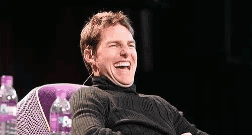 a man in a white sweater with a blue face is smiling