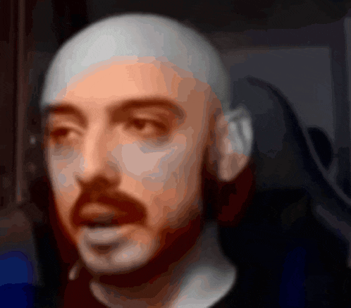 a blurry picture of a man with a beard and a bald head
