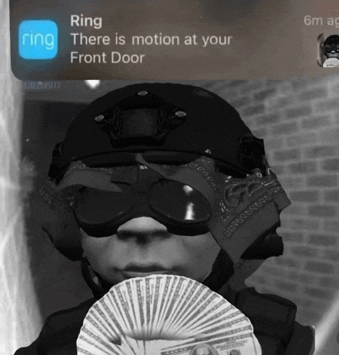 a person wearing a helmet and goggles holds a fan of money in front of a ring app