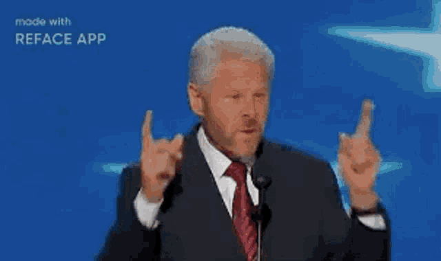 a man in a suit and tie is giving a middle finger .