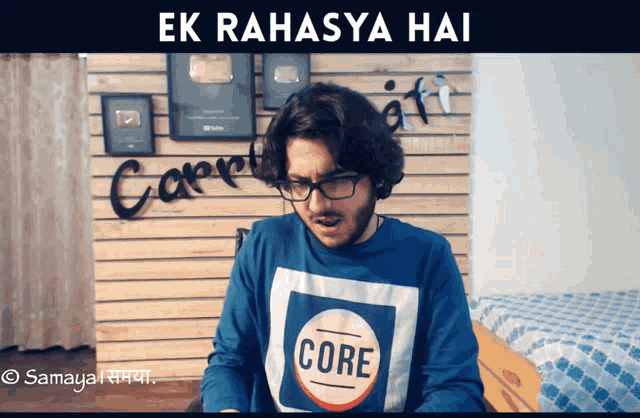 a man wearing glasses and a blue shirt with the word core on it