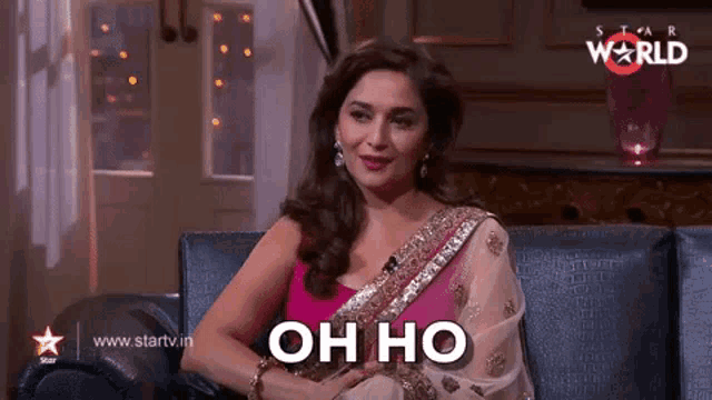 a woman in a pink saree is sitting on a couch with the words oh ho above her