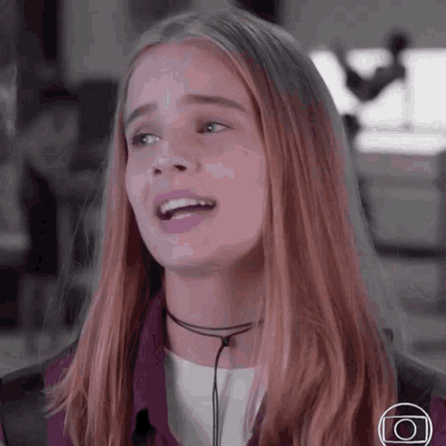 a close up of a girl 's face with a camera icon in the corner