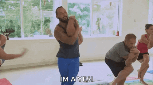 a group of people are doing yoga together in a gym and one of them is saying `` im a yes '' .