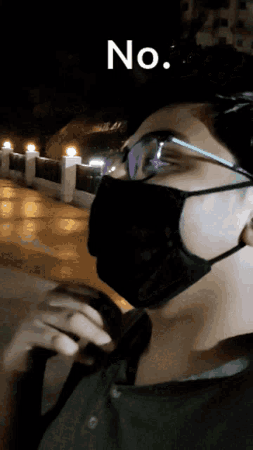 a person wearing glasses and a mask with the word no above them