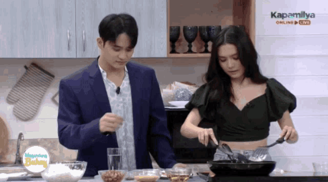 a man and a woman are cooking in a kitchen with a sign that says kapamilya online
