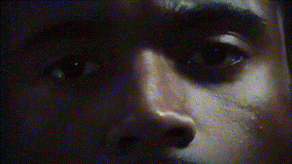 a close up of a person 's face in a dark room .