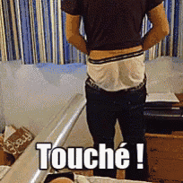 a man in underwear is standing in front of a box that says touche on it