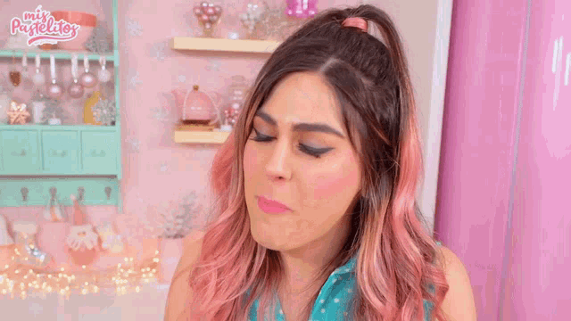 a woman with pink hair is making a funny face in front of a sign that says mix pastelitos