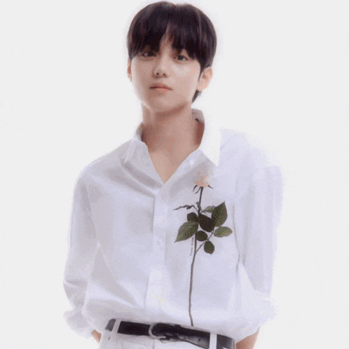 a man in a white shirt holds a bouquet of flowers in his hand