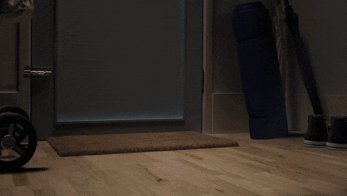 a person standing in a dark room with a light coming out of a doorway