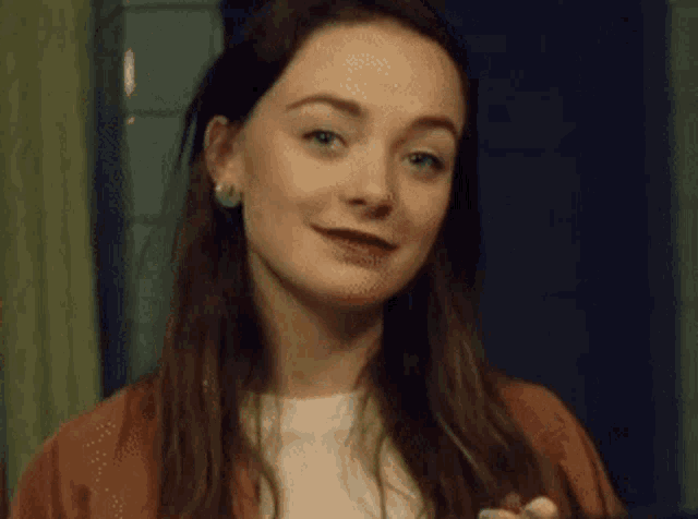 a woman is standing in front of a mirror looking at herself and smiling .
