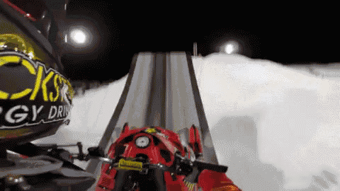 a person is riding a motorcycle down a snowy ramp with a sign that says cksr energy drink