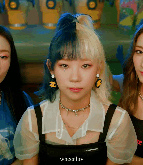 a girl with half blue and half blonde hair is wearing a necklace and earrings that say chanel