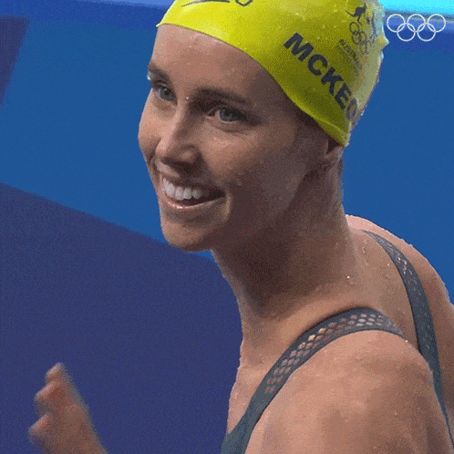 a woman wearing a yellow speedo swim cap with the name mckeon on it