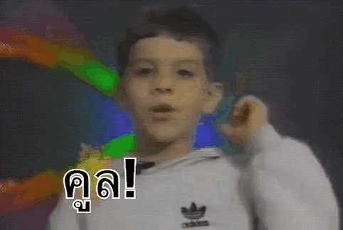 a young boy wearing an adidas sweatshirt is making a funny face .