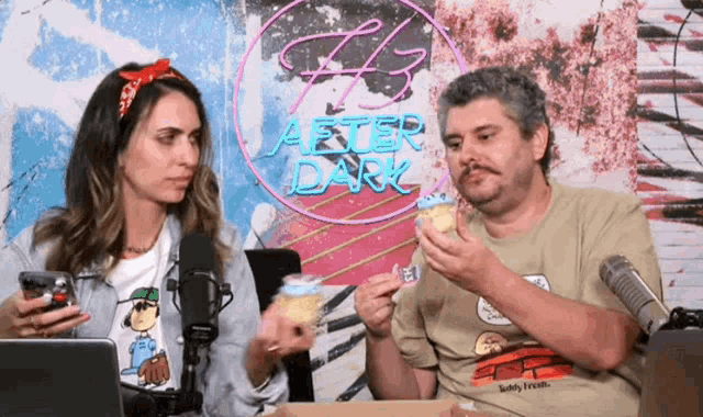 a man and a woman eating cupcakes in front of a neon sign that says after dark