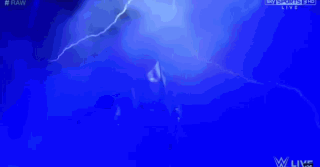 a man in a suit is standing in a dark room with smoke coming out of it .