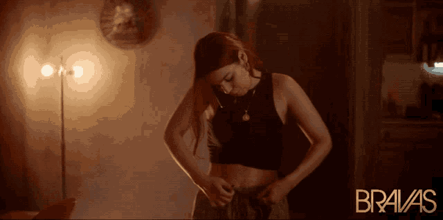a woman is standing in a dark room with bravas written on the bottom