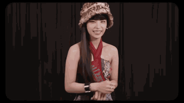 a woman wearing a leopard print hat and a red scarf is making a face
