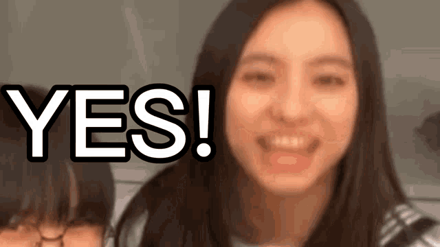 a girl is smiling in front of the word yes