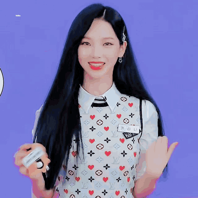 a girl with long black hair is wearing a louis vuitton shirt