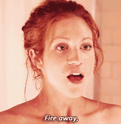 a woman with red hair says fire away