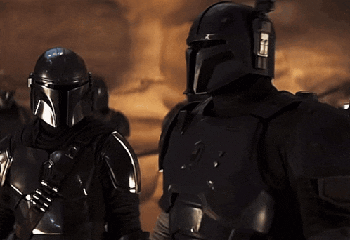 two men in black armor are standing next to each other and one of them has the number 21 on his helmet