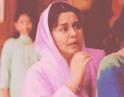 a woman wearing a pink hijab is sitting in front of a group of women .