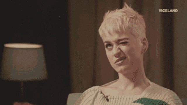 a woman with short blonde hair is making a funny face in front of a lamp and the words viceland on the bottom