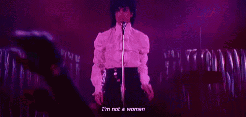 prince is standing in front of a microphone on a stage and singing .