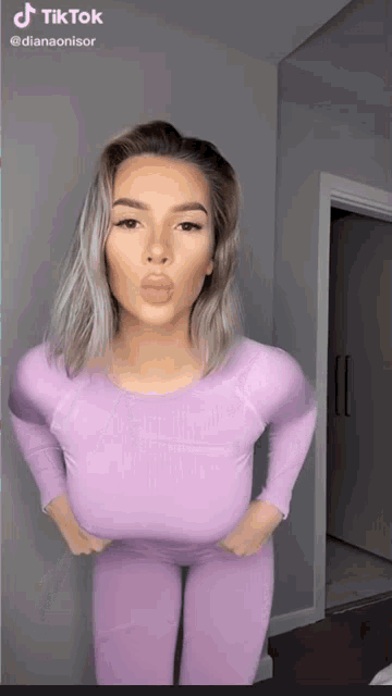 a tiktok video of a woman blowing a kiss while wearing purple