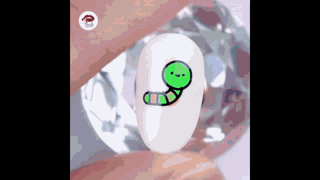 a person is holding a nail with a cartoon worm on it .