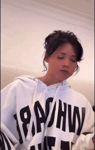 a woman wearing a white hoodie with the word 18ahw on it