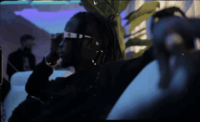 a man with dreadlocks wearing a pair of sunglasses with the letter o on them