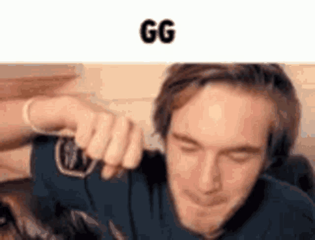 a man is holding another man 's hand over his ear .