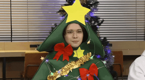 a man in a christmas tree costume with a star on top