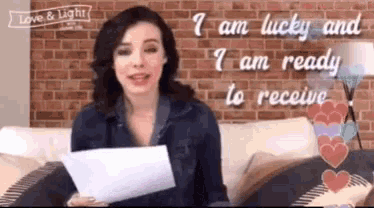 a woman sitting on a couch holding a piece of paper that says i am lucky and i am ready