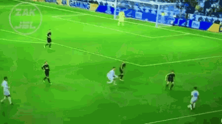 a group of soccer players are playing on a field with a sign that says zak