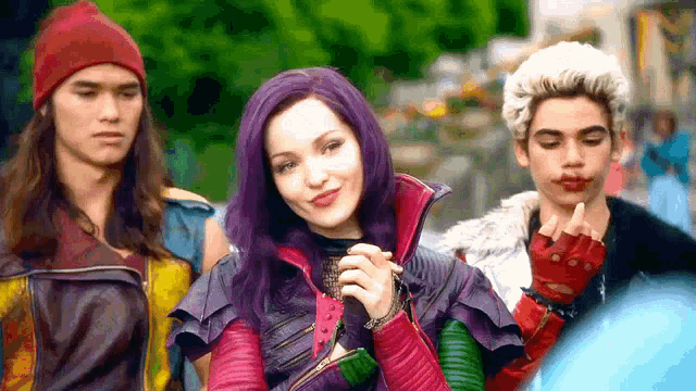 a group of people are standing next to each other and one of them has purple hair