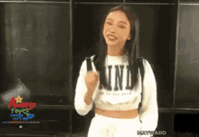 a woman wearing a white sweater that says kind