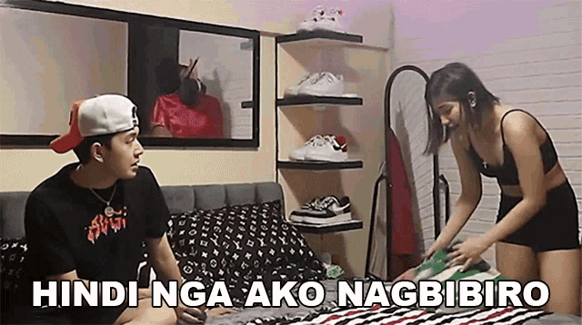 a man and a woman are sitting on a bed with the words hindi nga ako nagbibiro on the bottom