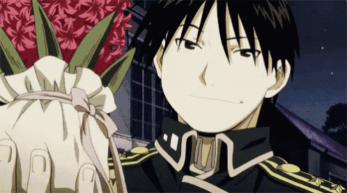 a man is holding a bouquet of flowers in his hand